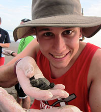 Kent Schnacke poses with a sea turtle in Costa Rica